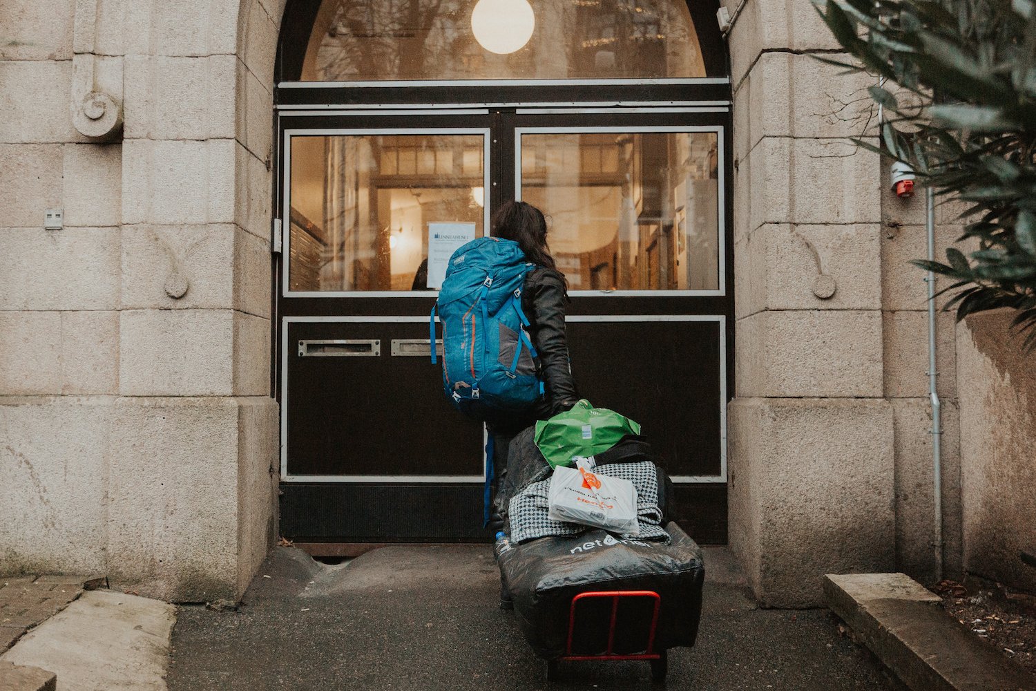 En kvinna går in genom porten på Räddningsmissionens härbärge 35:an i Göteborg.