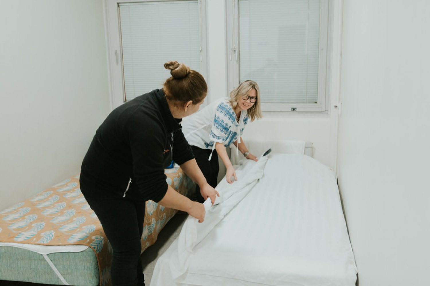 Två medarbetare på Räddningsmissionen i Göteborg bäddar en säng.