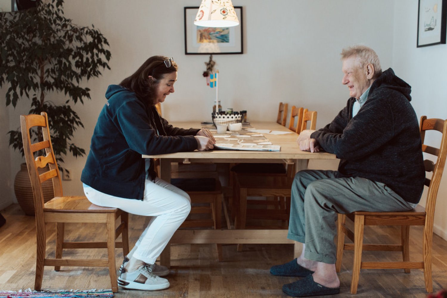 Två personer sitter vid köksbordet och skrattar.