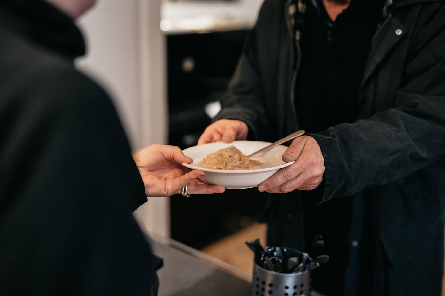 En skål gröt serveras till en person i hemlöshet.